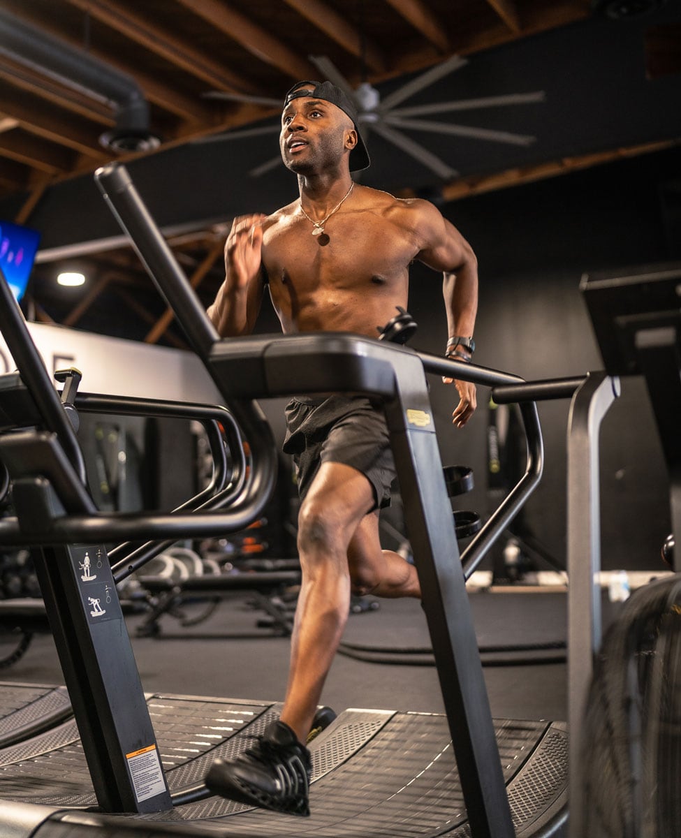 The coach is running in treadmill.